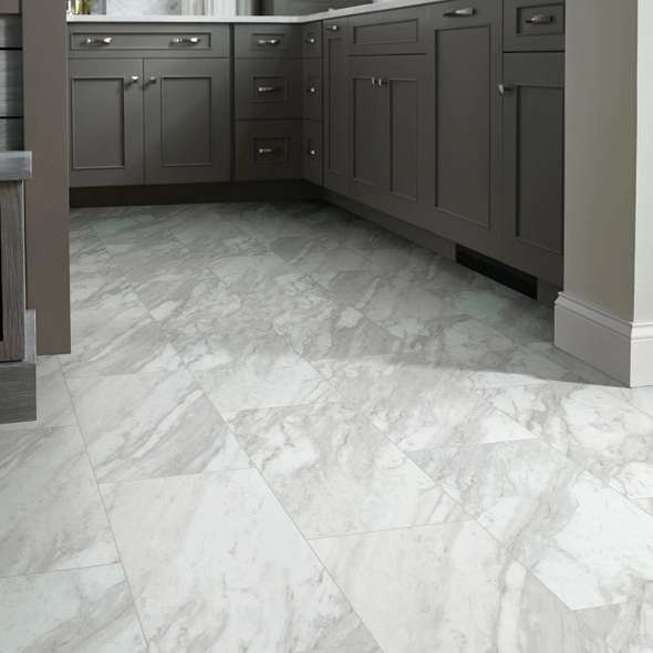 Dark paneled kitchen cabinets frame Shaw Paragon Tile Plus Oyster 1022V-01010, whose white-and-gray veining brightens this transitional interior.