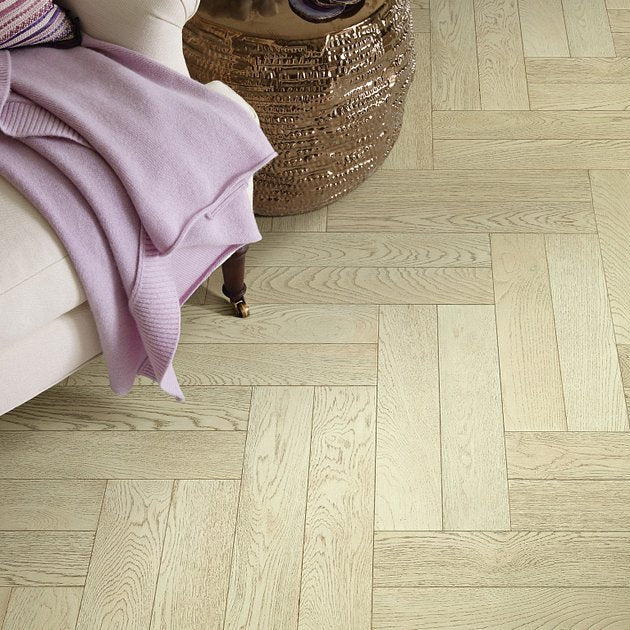 Shaw Empire Oak Herringbone Astor engineered hardwood flooring gives this living room a calm look, with natural wood color around sofa seating and the open floor area.