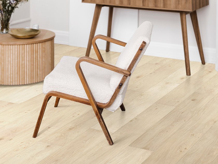Shaw Fresh Take Wishbone White wood-look vinyl planks have pale beige coloring, subtle grain and small knot accents in a sitting area with a timber-framed chair and tapered-leg console.