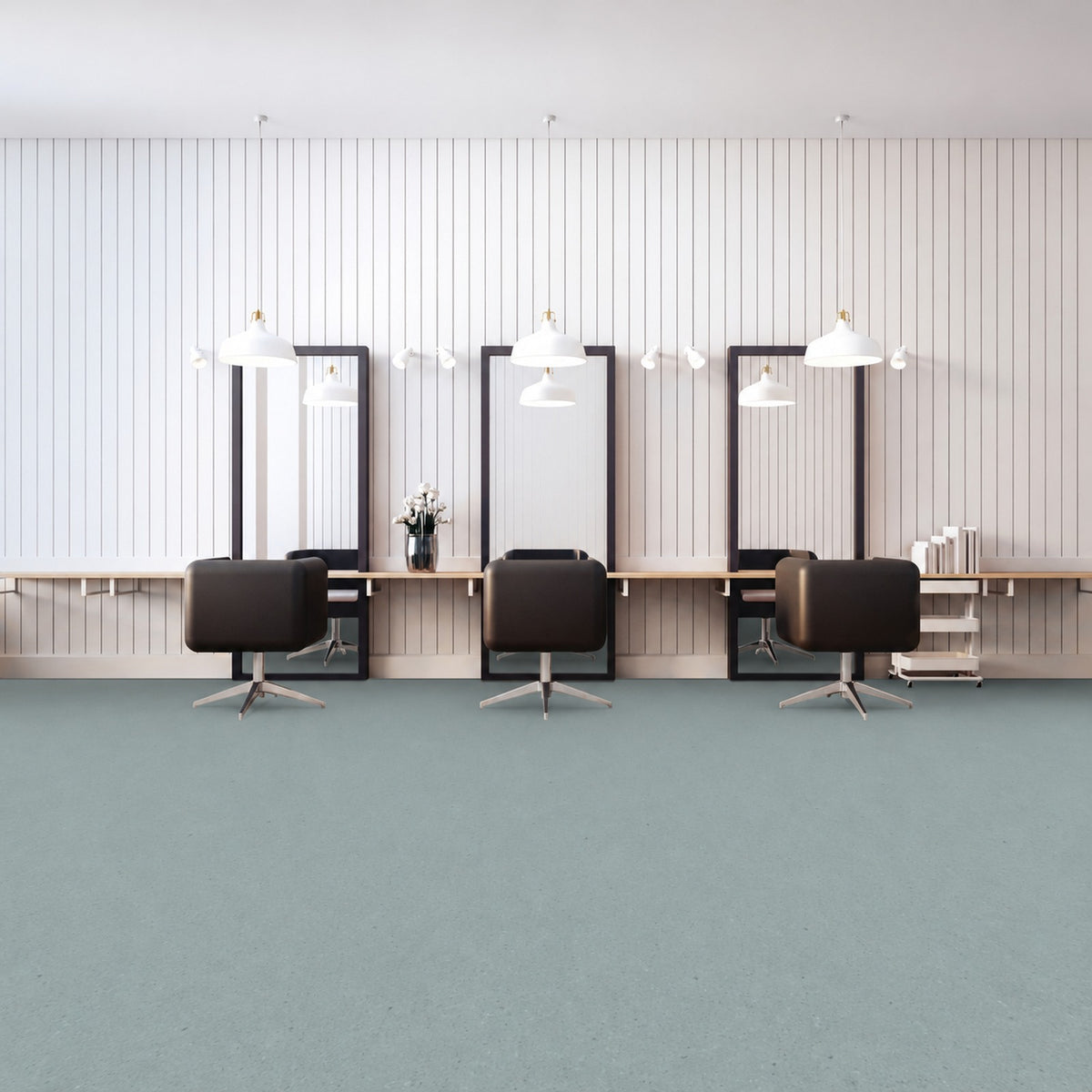 Armstrong Medintone Bergamot sheet vinyl, a pale aqua with a fine speckle, in a hair salon with three styling chairs and tall mirrors against a white paneled wall.