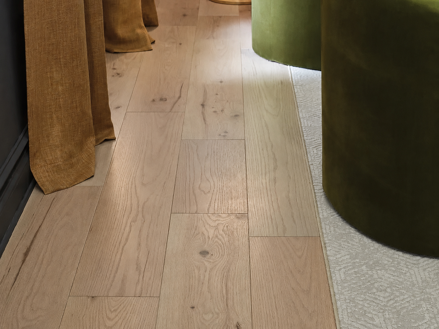 Living room view of Shaw Ensemble Caramel engineered hardwood flooring, showing honey caramel hardwood color near the furniture layout.