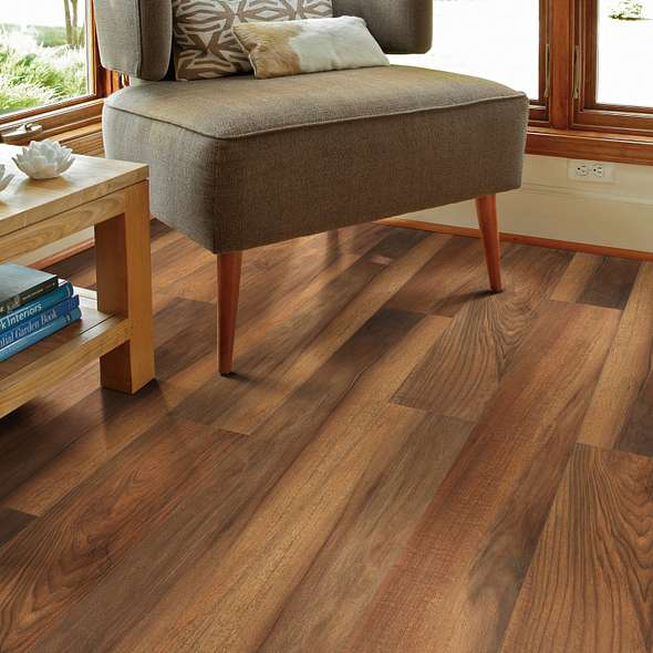 Shaw Endura Plus Amber Oak 0736V-00820 vinyl flooring is honey-brown tones and darker grain define beneath a window-side upholstered chair.