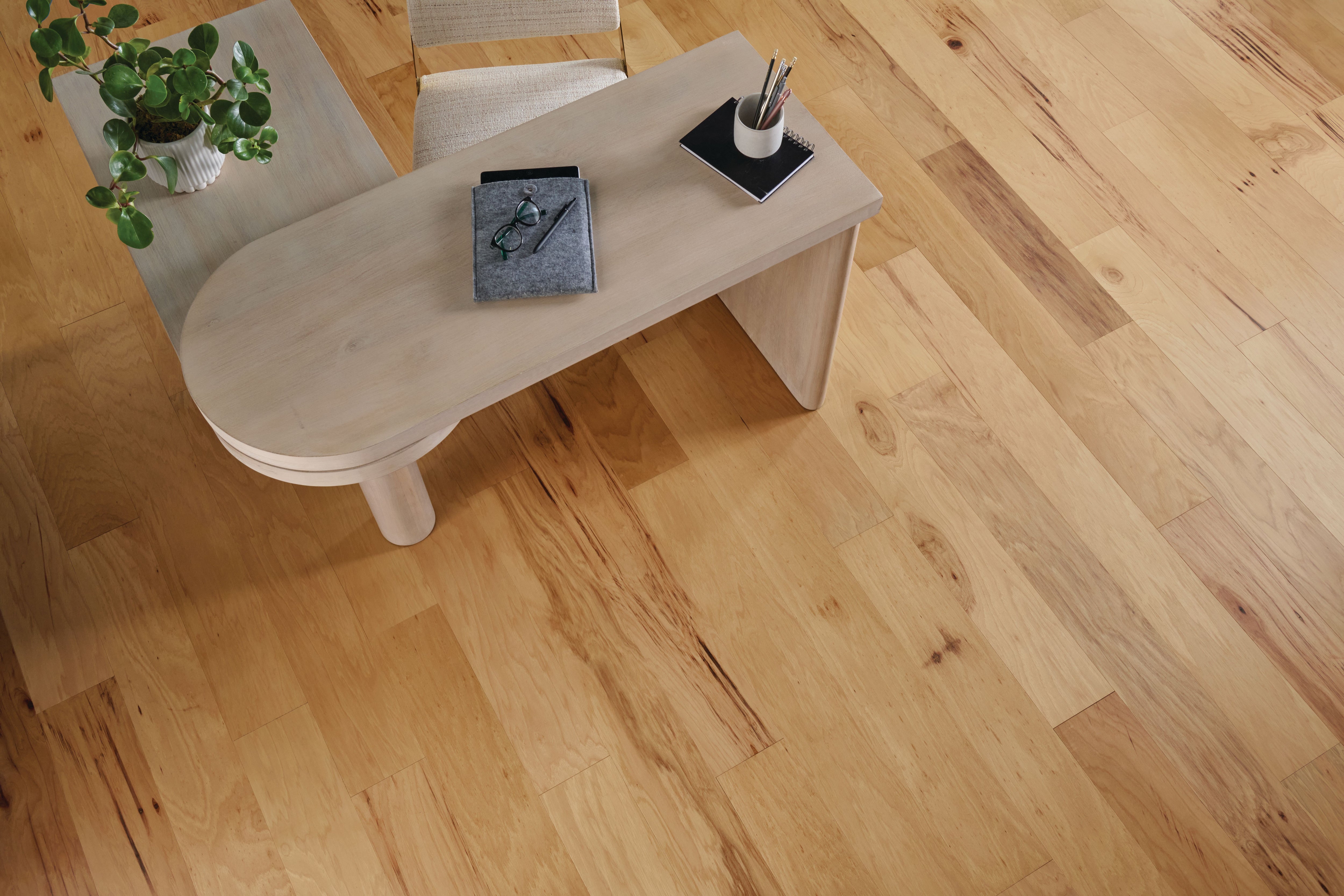 Top-down home office with a curved wood desk and warm Timeless Natural planks from Armstrong TimberTones LM22H-253S.