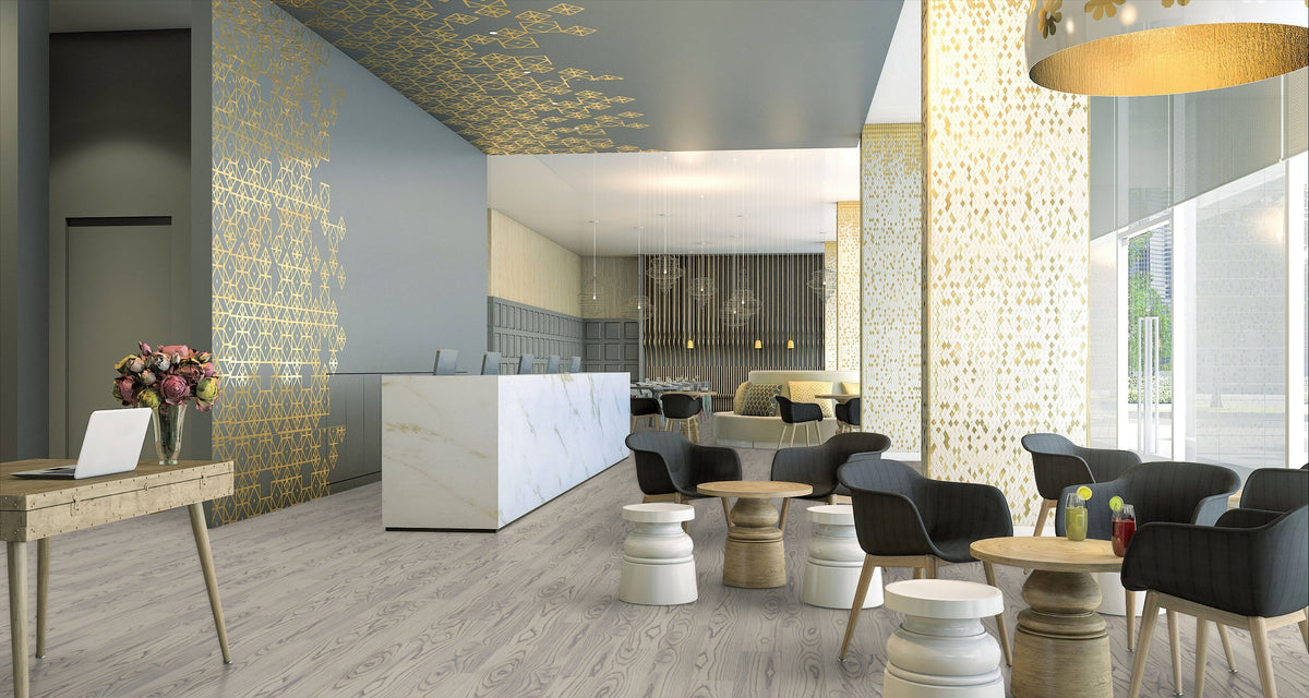 Armstrong Biome Earthen Amur luxury vinyl tile (LVT) flooring in a hotel-style lobby with a reception desk, lounge chairs, and patterned gold accents.