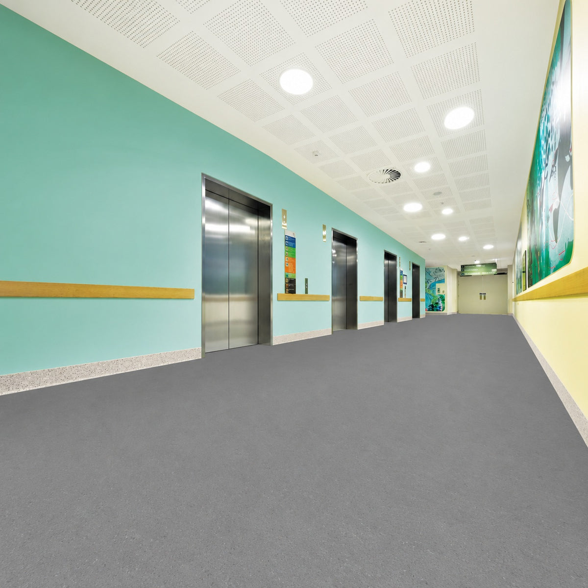 Armstrong Medintone Calming Gray sheet vinyl, a medium neutral gray with subtle flecks, in a healthcare elevator corridor with mint green walls and wood handrails.