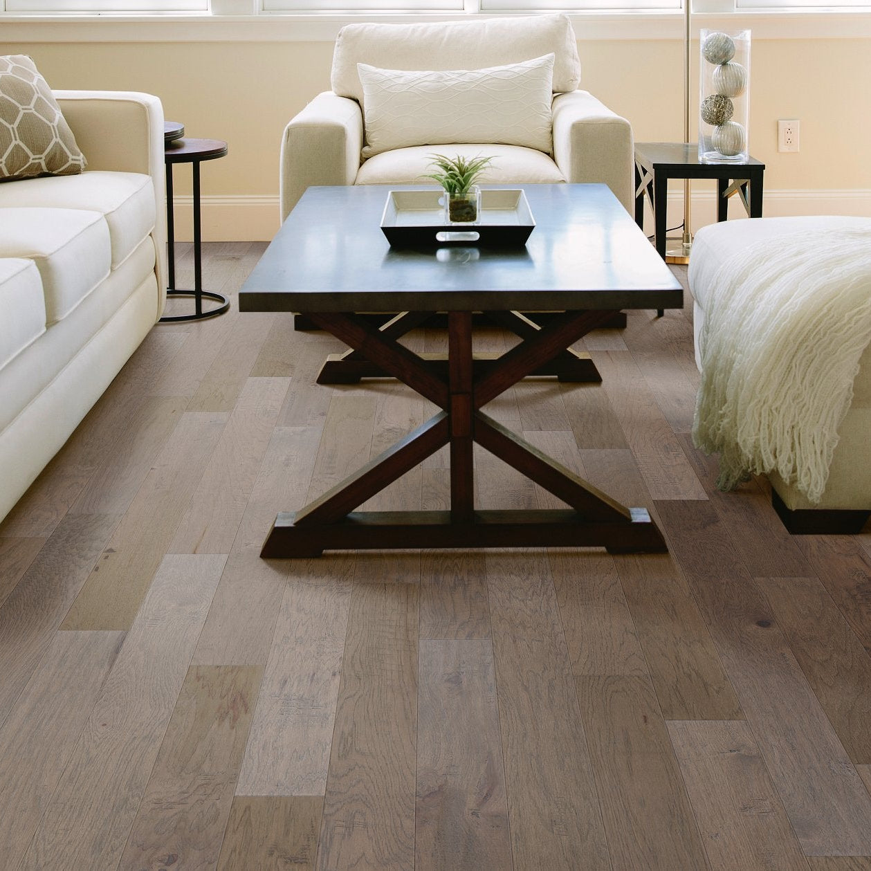 Shaw Hillside from the Arbor Place engineered hardwood flooring shapes this living room with wood-toned floorboards with calm color around sofa seating.