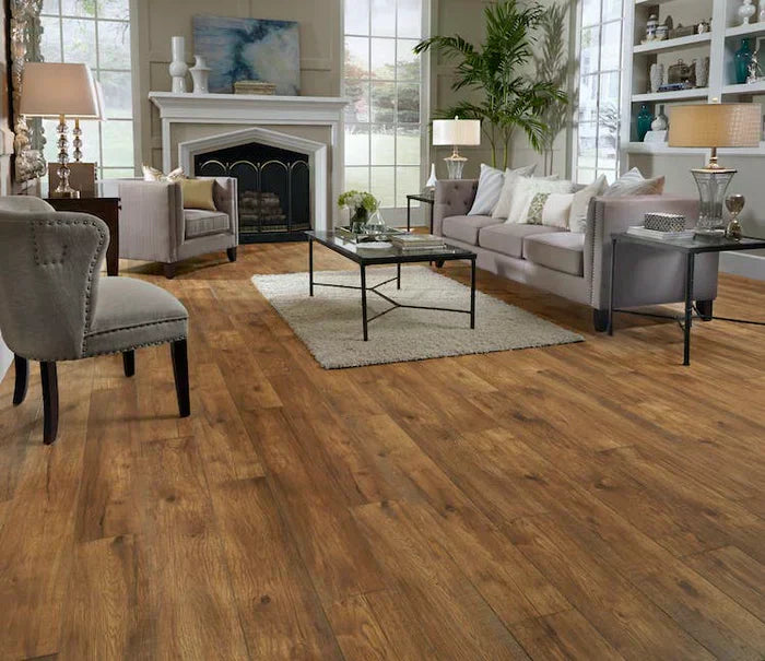 Cozy living room with wood flooring, modern furniture, a fireplace, and large windows, creating a bright and inviting atmosphere.