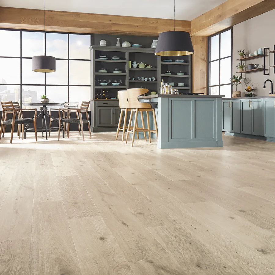Modern kitchen with Pergo Laminate floors, blue cabinetry, a dining area, and large windows providing natural light.
