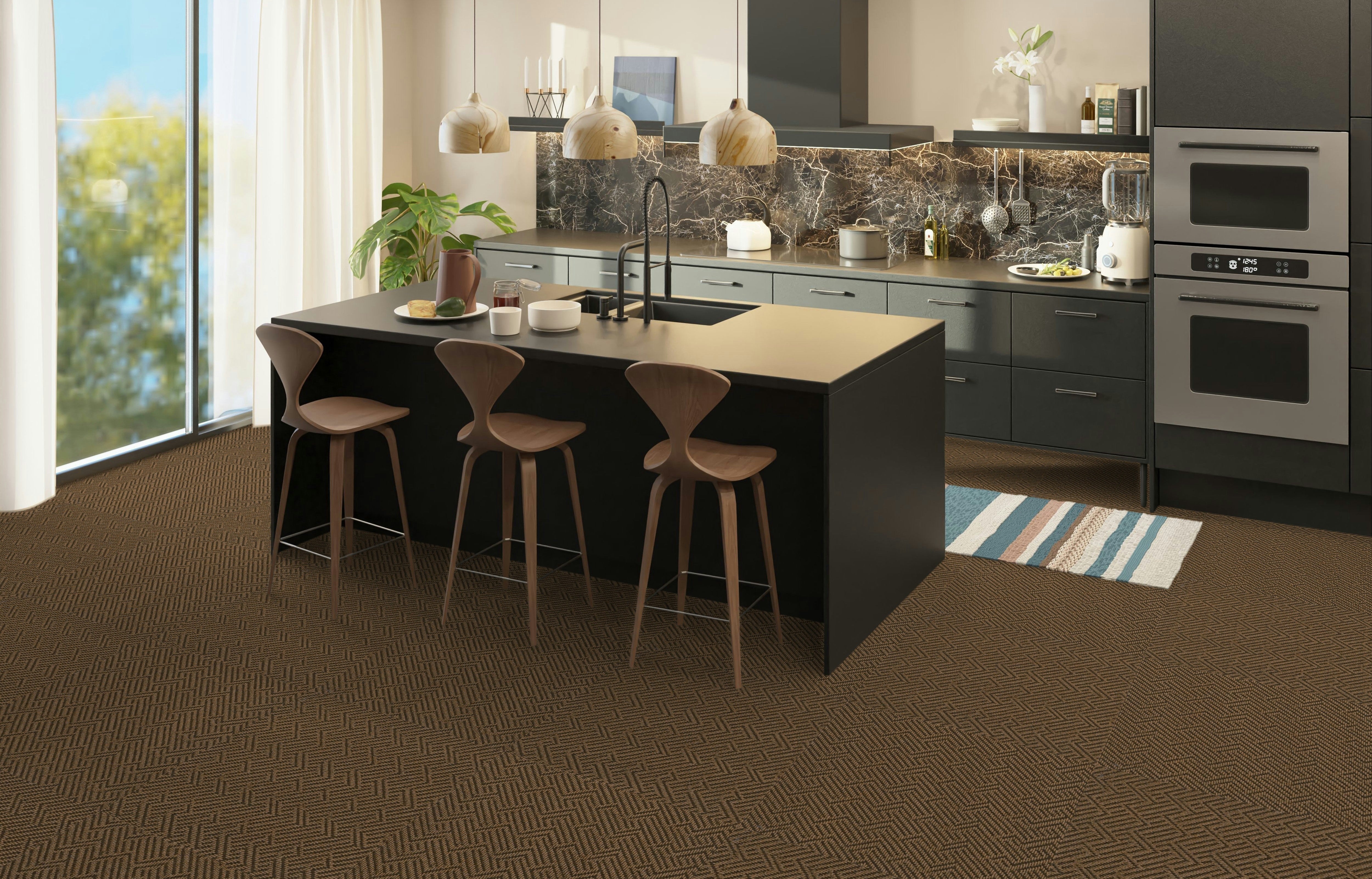 Modern kitchen with brown patterned carpet tile flooring, dark cabinets, a central island with wooden barstools, pendant lighting, and a marble backsplash near a sliding glass door.