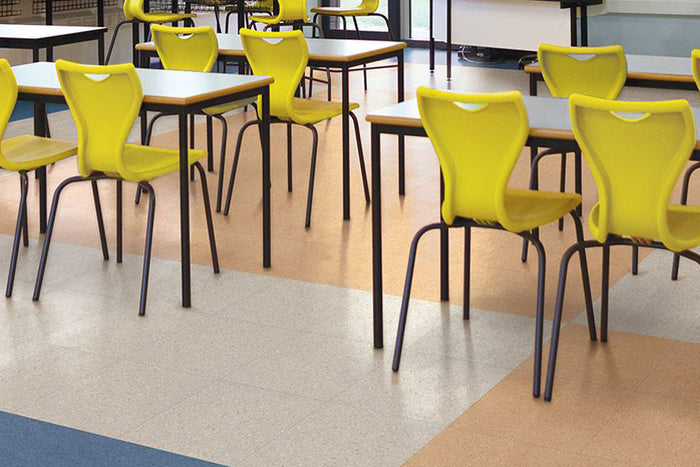 Armstrong Premium Excelon Crown Texture VCT tile flooring in a school cafeteria with yellow chairs, gray and beige tiles, and blue border accents