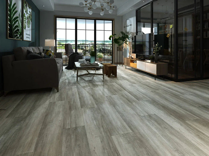 Modern living room with Stanton Floors 2000 Exotica 306 SPC luxury vinyl plank flooring in a light gray wood look.