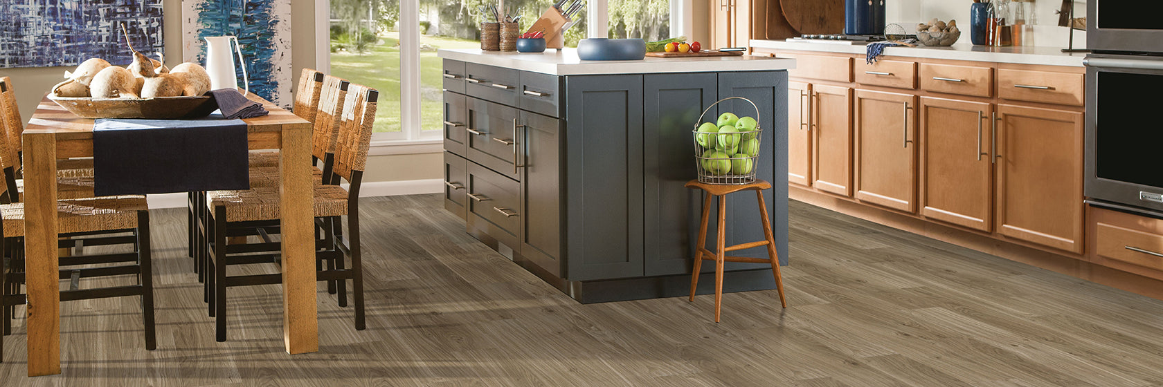 A cozy kitchen featuring Armstrong American Charm wood flooring and a stylish dining table, creating a warm atmosphere.