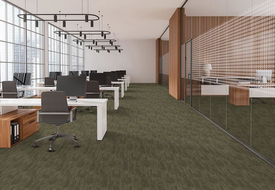 Bright modern office with lush green carpet and large windows, creating an inviting atmosphere for productivity.