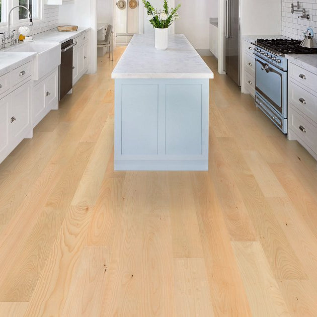 Shaw Natural Classics Hard Maple engineered hardwood flooring gives this living room a polished look, with natural wood color around sofa seating and the open floor area.