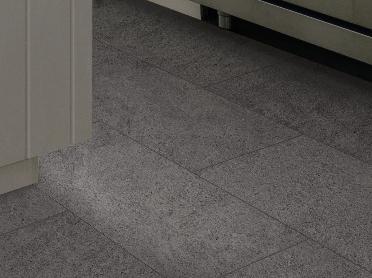 A close kitchen view pairs Charcoal 1022V-00943 from Shaw Paragon Tile Plus with pale cabinetry and a stainless appliance, revealing its finely mottled surface pattern.