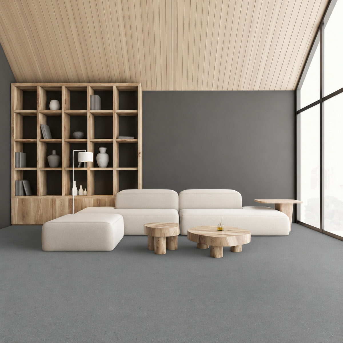 Armstrong Medintone Haze Gray sheet vinyl, a medium gray with a fine speckle, in a lounge with a cream modular sofa, wood shelving and floor-to-ceiling windows.
