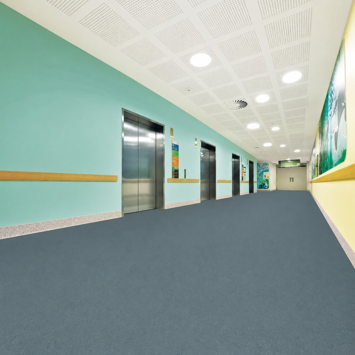 Armstrong Medintone Tranquil Breeze sheet vinyl, a slate blue-gray with fine flecks, in a healthcare elevator corridor with mint green walls and wood handrails.