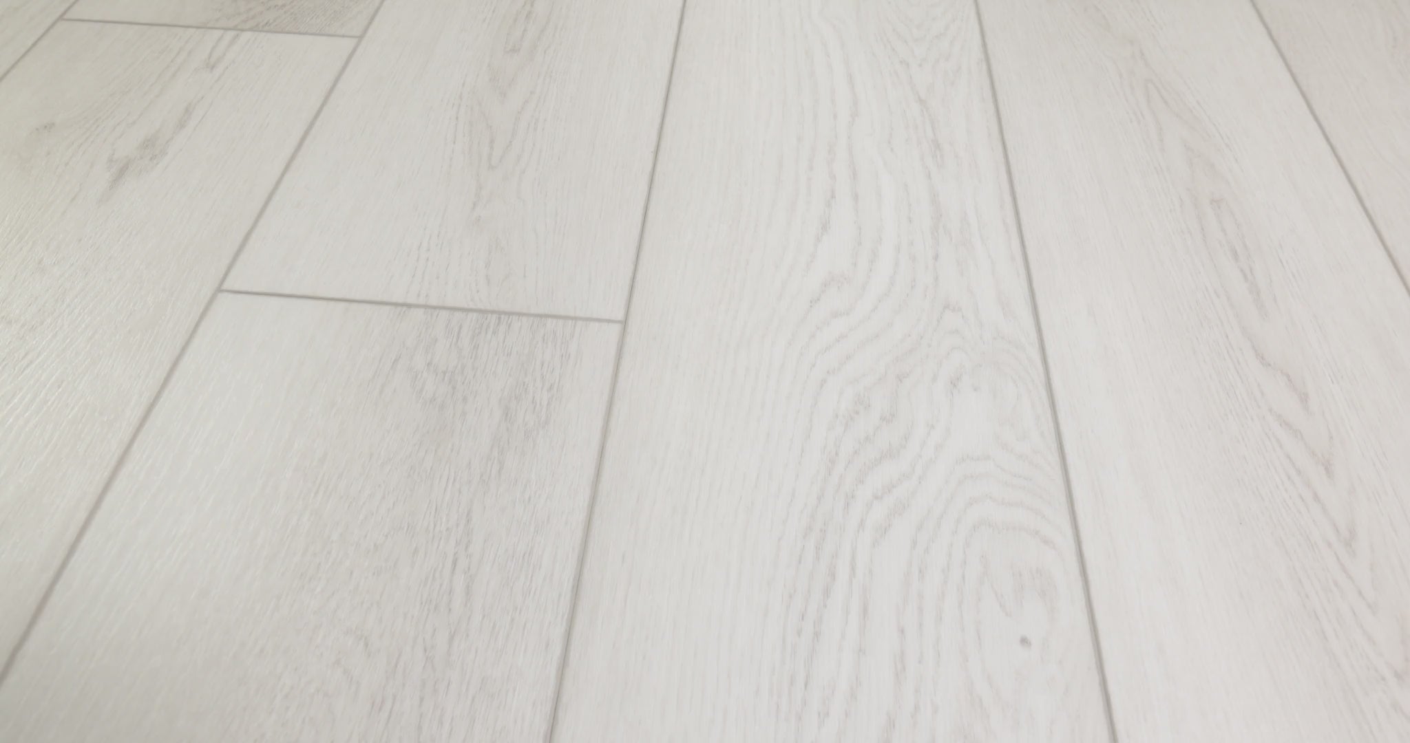 Long boards with painted bevels establish the layout of Shaw Paladin Plus Feather Grey (0278V-01178). Silvery gray vinyl, faint beige patches and delicate grain appear as the perspective changes. A ScufResist finish is confirmed by Shaw; modern and contemporary settings match the gallery styling. Use Floor City to explore Feather Grey through its video.