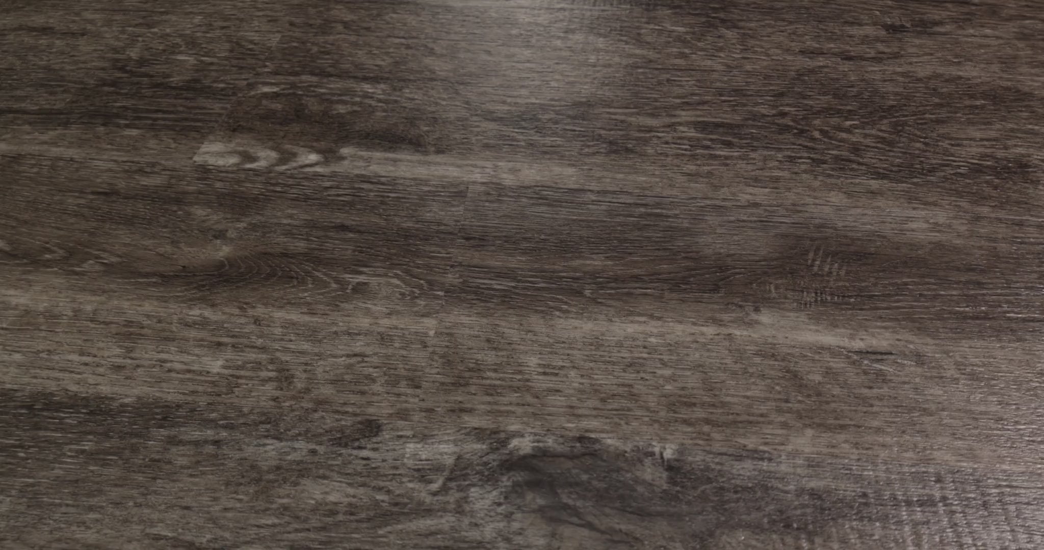 Smoky gray and dark brown streaks give Shaw Endura Plus Smoky Oak a pronounced oak-style pattern. Micro-beveled edges separate the 7-inch-wide, 48-inch-long SPC vinyl boards, which are 4.8 mm thick with a 12 mil wear layer. Its strong grain contrast offers character for industrial and rustic room designs.