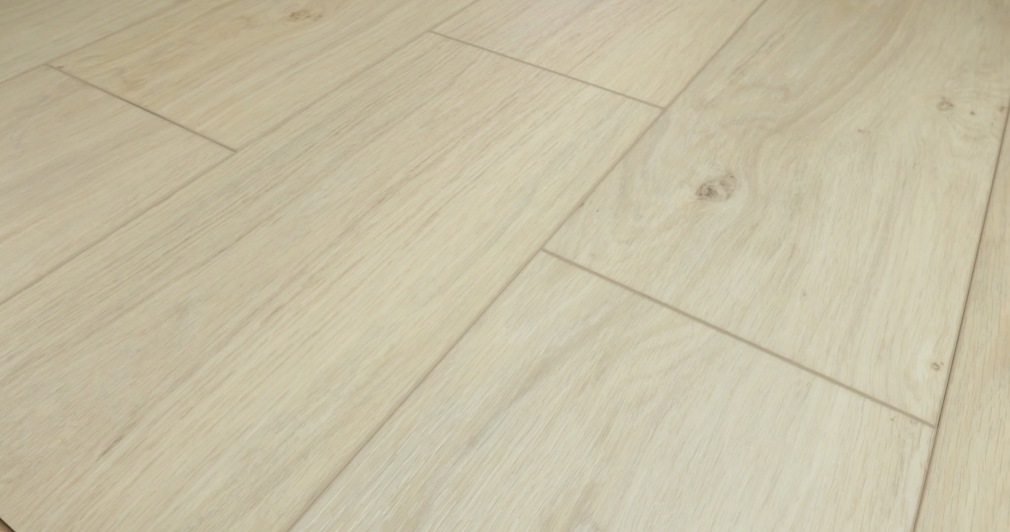 Close views of Wishbone White luxury vinyl flooring from Shaw Fresh Take, showing pale beige planks, flowing wood grain, small knots and visible joints as the viewing angle changes.