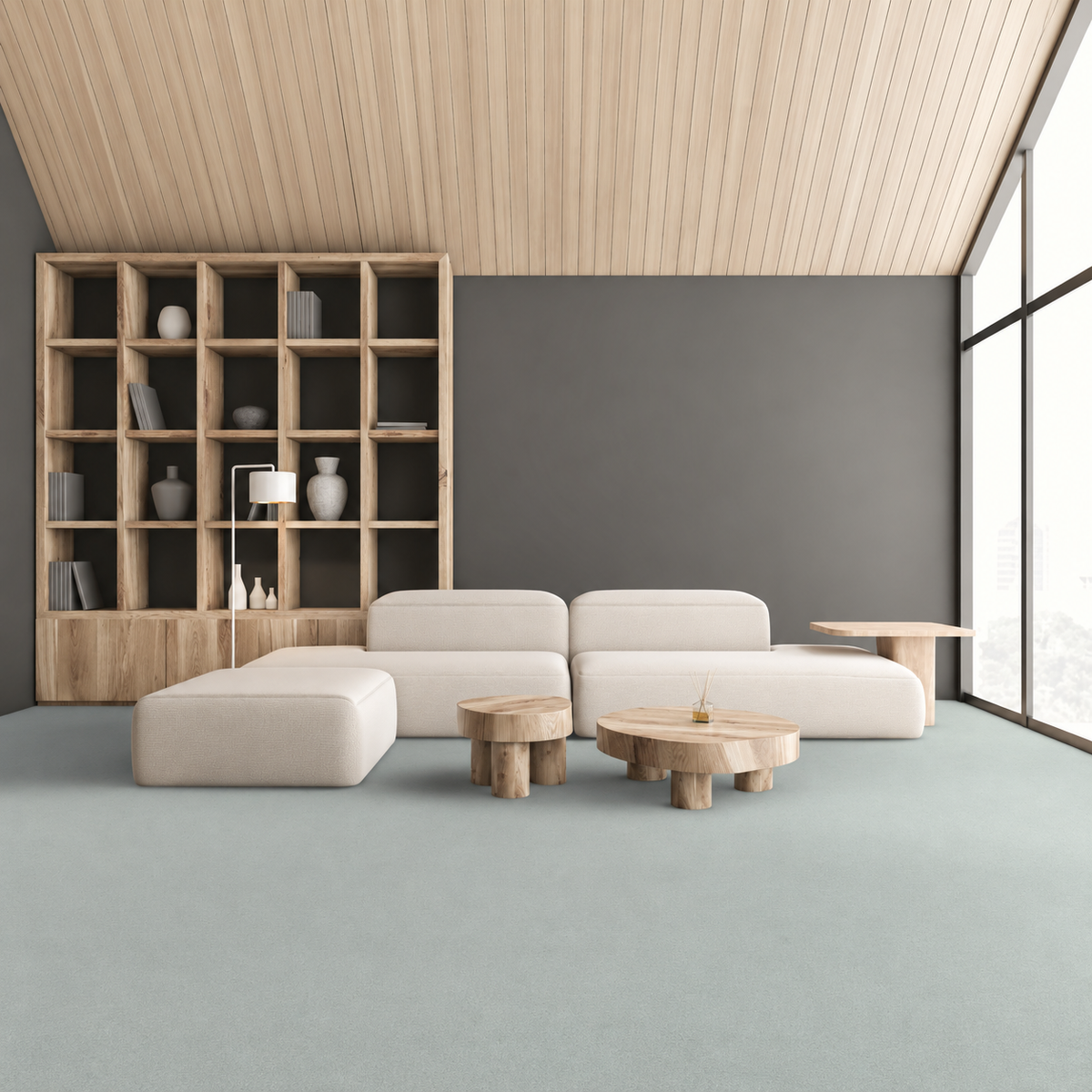 Armstrong Medintone Sea Salt sheet vinyl, a pale blue-gray, in a lounge with a cream modular sofa, wood shelving and floor-to-ceiling windows.