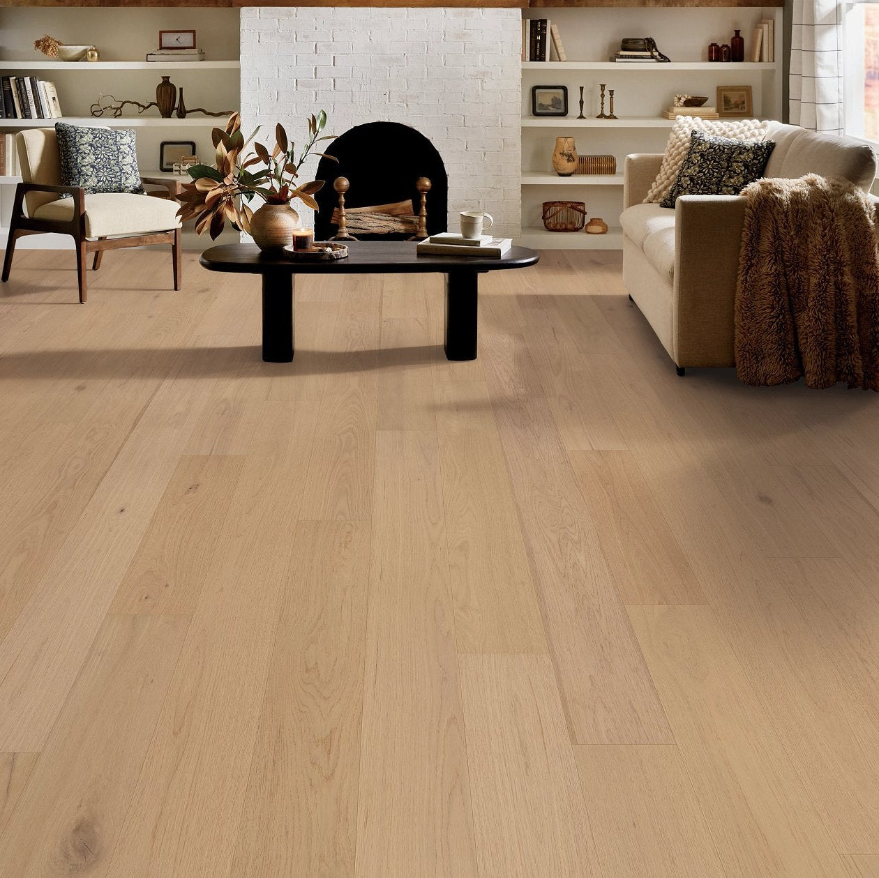 Shaw Cornerstone II Sun Glow engineered hardwood flooring gives this living room a polished look, with natural wood color around sofa seating and the open floor area.